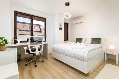 a bedroom with a bed and a desk with a computer at City Castle apartment 3BR in central Plovdiv in Plovdiv