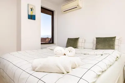 a white bedroom with a large white bed with towels on it at City Castle apartment 3BR in central Plovdiv in Plovdiv