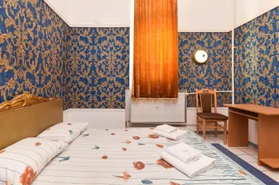 a room with a bed and a desk and blue wallpaper at Historical Lion's Bridge 1-Bedroom Apartment by Flat Mаnager in Sofia