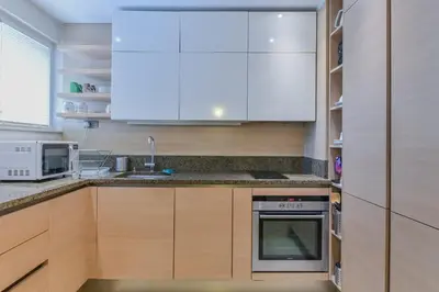 a kitchen with white cabinets and a stove at Stylish One-bedroom Flat with Amazing City View by Flat Mаnаger in Sofia