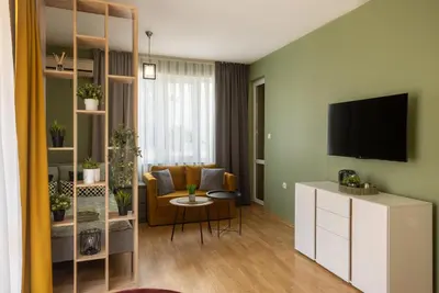 a living room with a couch and a tv on a wall at Domus Magnolia Studio In The Top Center in Plovdiv