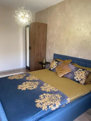 a bedroom with a blue bed and a chandelier at Djanina 3 in Sandanski