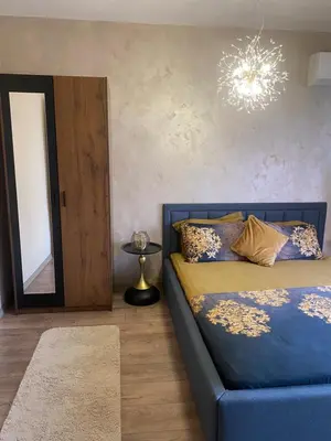 a bedroom with a blue bed and a mirror at Djanina 3 in Sandanski