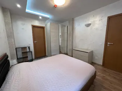 a bedroom with a white bed and a television at Tulip Apartment High-End, Grand Resort Pamporovo in Pamporovo