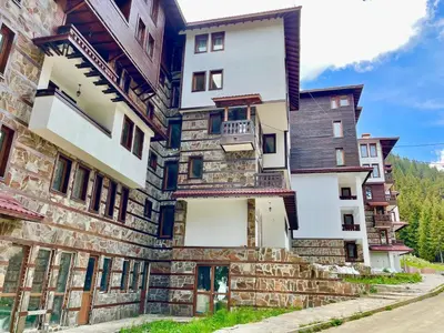 a building in the mountains with a stone facade at Tulip Apartment High-End, Grand Resort Pamporovo in Pamporovo