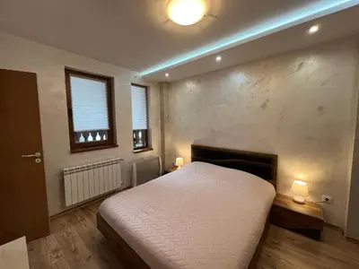 a bedroom with a white bed and a fireplace at Tulip Apartment High-End, Grand Resort Pamporovo in Pamporovo