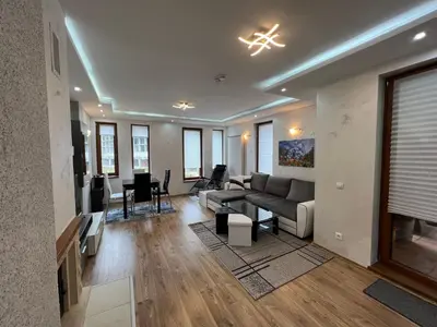 a living room with a couch and a table at Tulip Apartment High-End, Grand Resort Pamporovo in Pamporovo