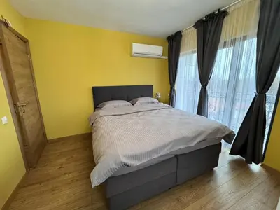 a bedroom with a bed and a yellow wall at Spacious sunny flat with 2 bedrooms in the heart of Plovdiv in Plovdiv