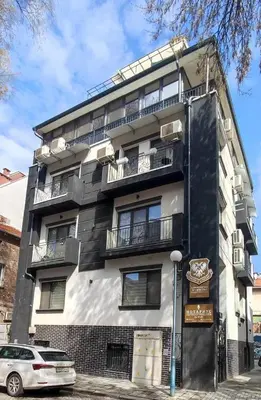 a black and white building with a car parked in front at Spacious sunny flat with 2 bedrooms in the heart of Plovdiv in Plovdiv