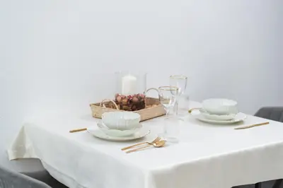 a white table with plates and a candle on it at Apartment Velik in Sandanski