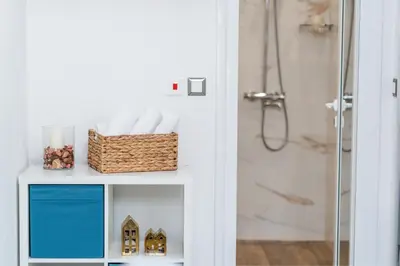 a bathroom with a shelf with a basket of towels at Apartment Velik in Sandanski