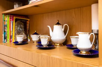 a shelf with several tea pots and cups on it at Quiet apartment near the center by Flat Mаnager in Plovdiv
