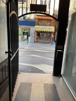 an open door to a street with a person walking past a store at Nice and cozy in Sofia