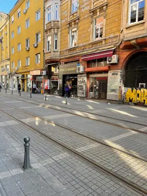 an empty city street with buildings and train tracks at Nice and cozy in Sofia