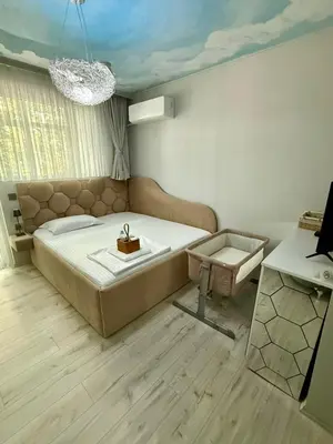a bedroom with a large bed and a table at ElenartLux - Baby Cot - Pets Allowed - Free Parking & Fast Wi-Fi in Plovdiv