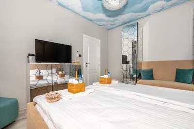 a bedroom with a large bed with a tv on the ceiling at ElenartLux - Baby Cot - Pets Allowed - Free Parking & Fast Wi-Fi in Plovdiv
