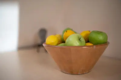 a wooden bowl of fruit sitting on a floor at Studio Talisman V in Sofia
