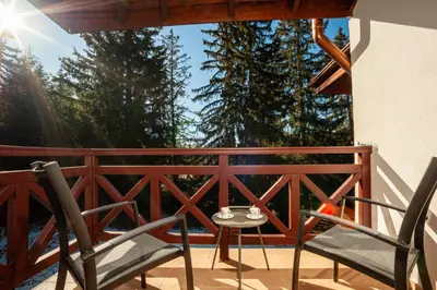a pair of chairs and a table on a balcony at Гнездото на Гълъба in Ostrets