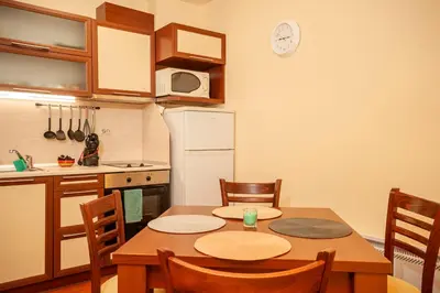 a kitchen with a table and chairs and a kitchen with a clock at Гнездото на Гълъба in Ostrets