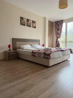 a bedroom with a bed and a wooden floor at Green View Studios in Sandanski