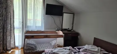 a bedroom with a bed and a tv on the wall at Къща за гости Брязово in Ribarica