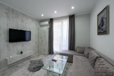 a living room with a couch and a tv on a wall at Secret Guest House in Plovdiv