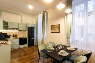 a kitchen and dining room with a table and chairs at Klimt's Puzzle Suite in Sofia