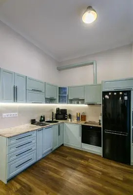 a kitchen with white cabinets and a black refrigerator at Klimt's Puzzle Suite in Sofia