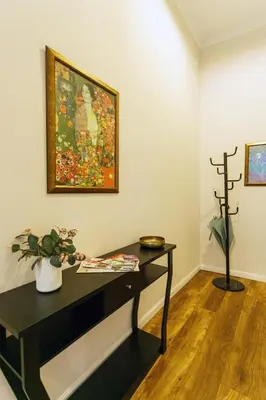 a room with a table and a painting on the wall at Klimt's Puzzle Suite in Sofia