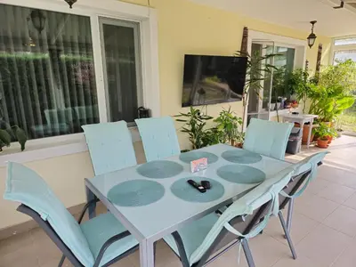 a dining room table and chairs in a yard at Къща за гости Спирката in Spatovo