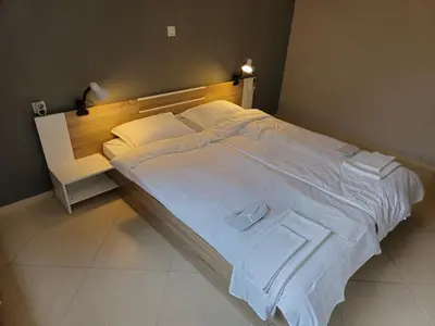 a bedroom with a large bed with white sheets and pillows at Къща за гости Спирката in Spatovo
