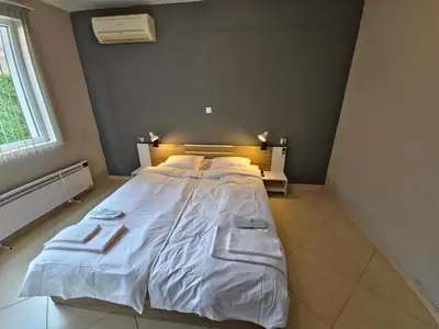 a bedroom with a large white bed in a room at Къща за гости Спирката in Spatovo