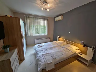 a bedroom with a large bed with two towels on it at Къща за гости Спирката in Spatovo