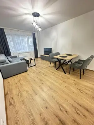 a living room with a table and chairs and a couch at The View Residences & private parking in Sofia