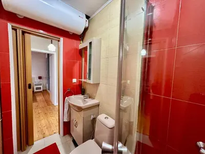 a red bathroom with a toilet and a sink at Mary's Guesthouse in Banya