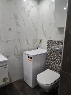 a white bathroom with a toilet and a sink at The Nest in Sofia