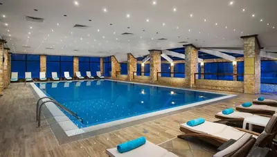 a large swimming pool with lounge chairs in a building at Donna Spa hotel Sveti Spas in Velingrad