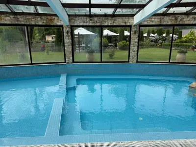a large swimming pool in a house with windows at Donna Spa hotel Sveti Spas in Velingrad