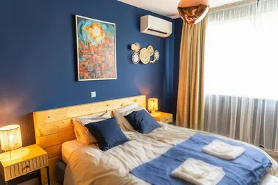 a bedroom with a large bed with blue walls at Saltwater Apartments in Sandanski