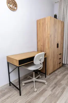 a desk with a white chair next to a wooden cabinet at Saltwater Apartments in Sandanski