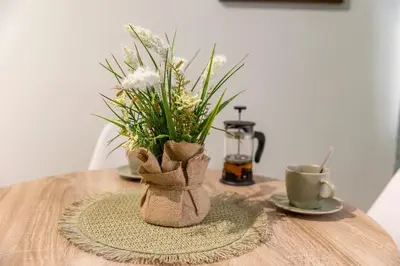 a vase with flowers in it sitting on a table at Saltwater Apartments in Sandanski