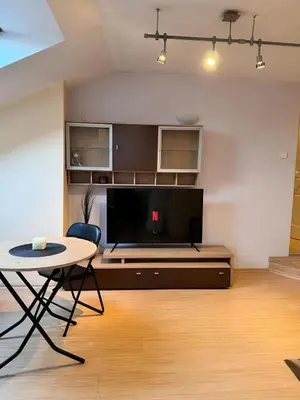 a living room with a table and a large tv at Sofia Central Cozy Apartment in Sofia