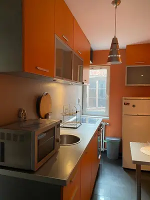 a kitchen with orange cabinets and a sink at Sofia Central Cozy Apartment in Sofia