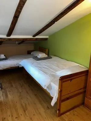 a bedroom with two beds and a green wall at Sofia Central Cozy Apartment in Sofia