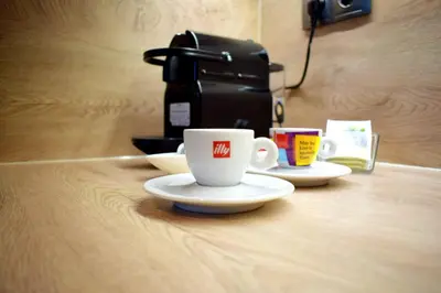 a coffee cup and saucers on a table with a coffee maker at Studio 42 Plovdiv in Plovdiv