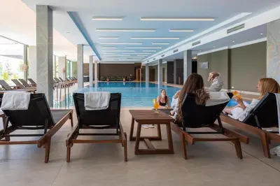 a group of people sitting in chairs in front of a swimming pool at Saint Sofia Golf Club, Hotel and SPA in Robertowo