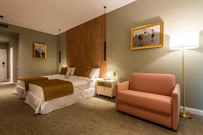 a hotel room with a bed and a chair at Saint Sofia Golf Club, Hotel and SPA in Robertowo