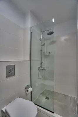 a bathroom with a toilet and a glass shower at Toronto Cozy Studio near UNSS and NSA w Fast WiFi in Sofia
