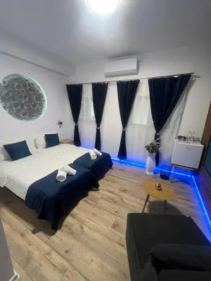two beds in a room with blue lights at BoxRoom3 in Kyustendil