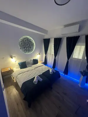 a bedroom with a large bed with blue lights at BoxRoom3 in Kyustendil